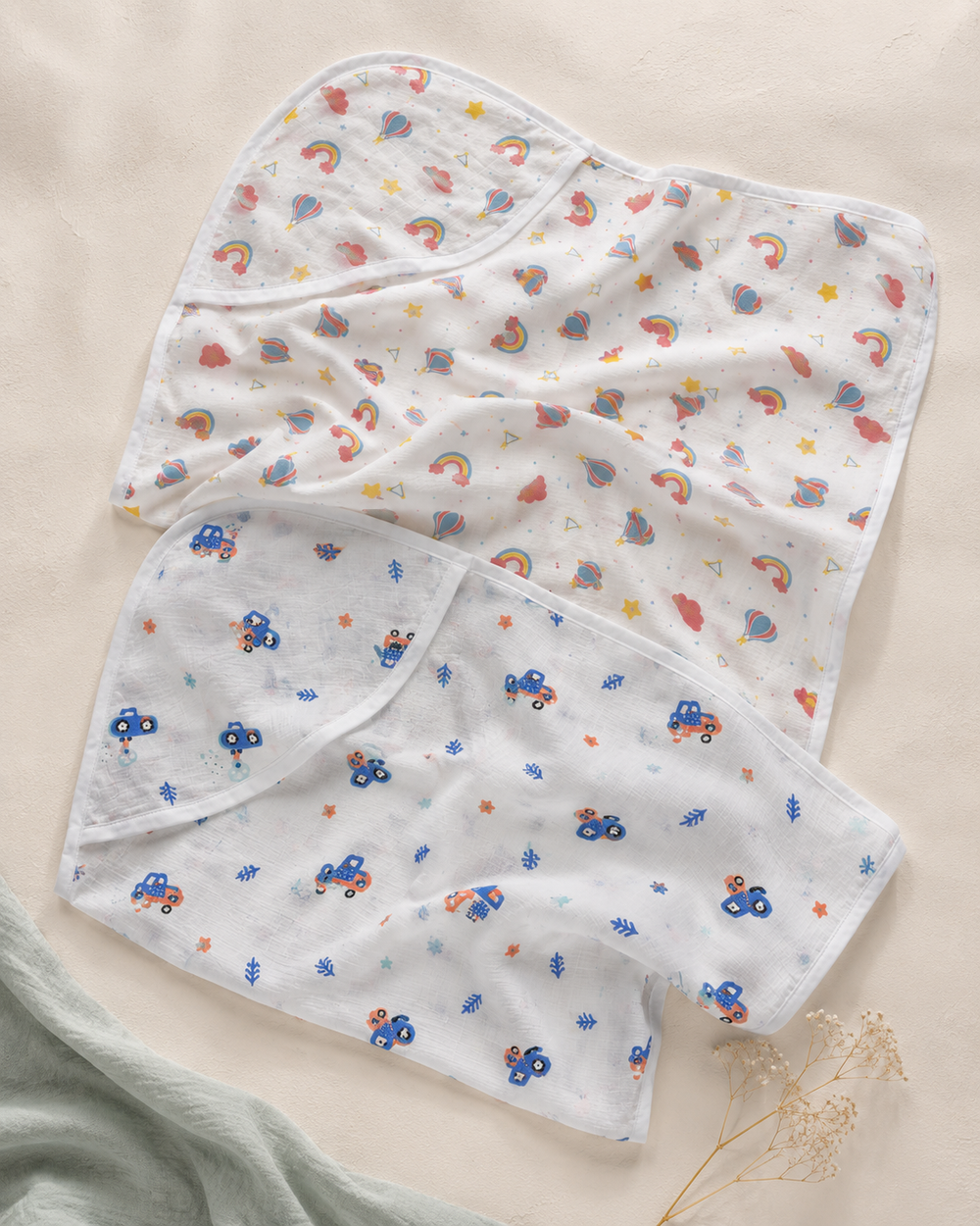 Maison Joey pack of two hooded muslin towels in rainbow and vehicle prints on a warm ivory editorial background