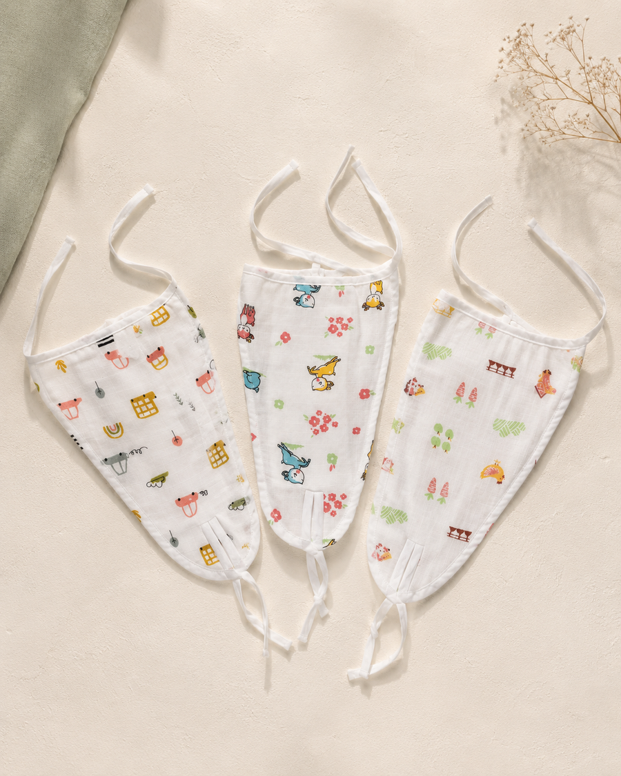 Maison Joey pack of three tie-on muslin nappies in assorted playful prints on a warm ivory editorial background