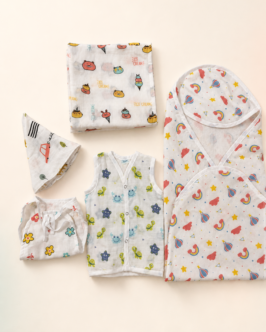 Maison Joey muslin baby gift set on a seamless warm ivory studio background